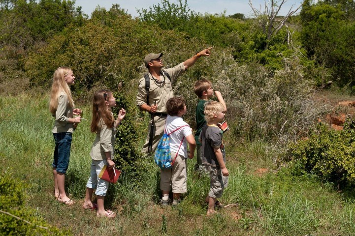 Kinder unternehmen im Kwandwe Private Game Reserve eine Buschwanderungen mit einem Guide