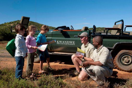 Guides im Kwandwe Private Game Reserve zeigen Kindern den südafrikanischen Busch