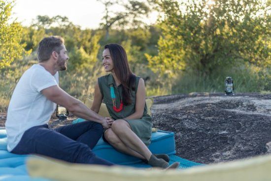 Flitterwochen im Sabi Sand Game Reserve: Ein Paar sitzt beim Sundowner im südafrikanischen Busch