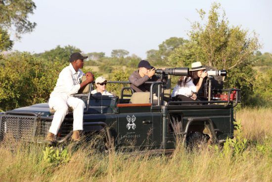 Aktivitäten bei Londolozi: Safari-Urlauber machen in einem speziell für Foto-Safaris gebauten Fahrzeug Fotos