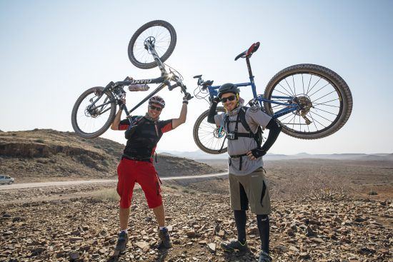 Rhino-Africa-Mitarbeiter halten ihre Mountainbikes in die Höhe