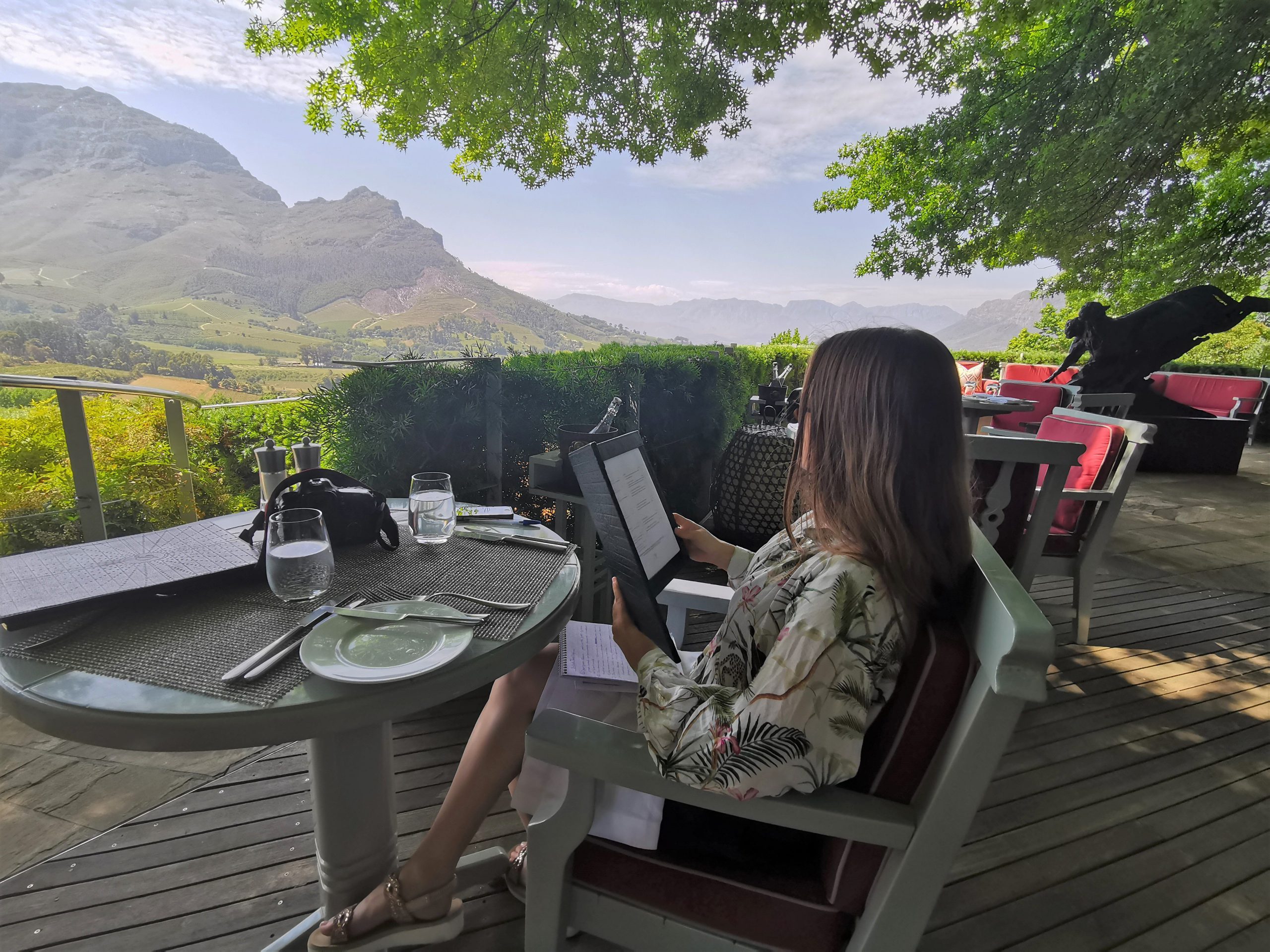 Katharina Riebesel liest auf der Terrasse des Delaire Graff Restaurants die Speisekarte