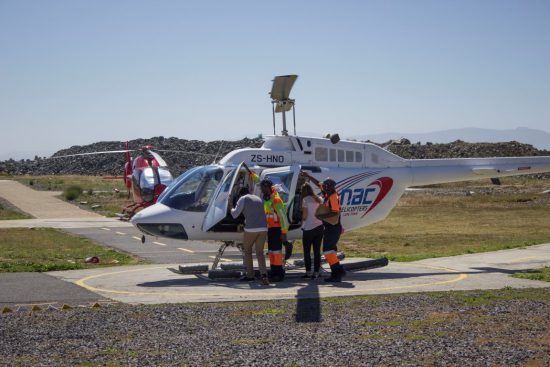 Rhino-Africa-Mitarbeiter steigen in einen Helikopter von NAC