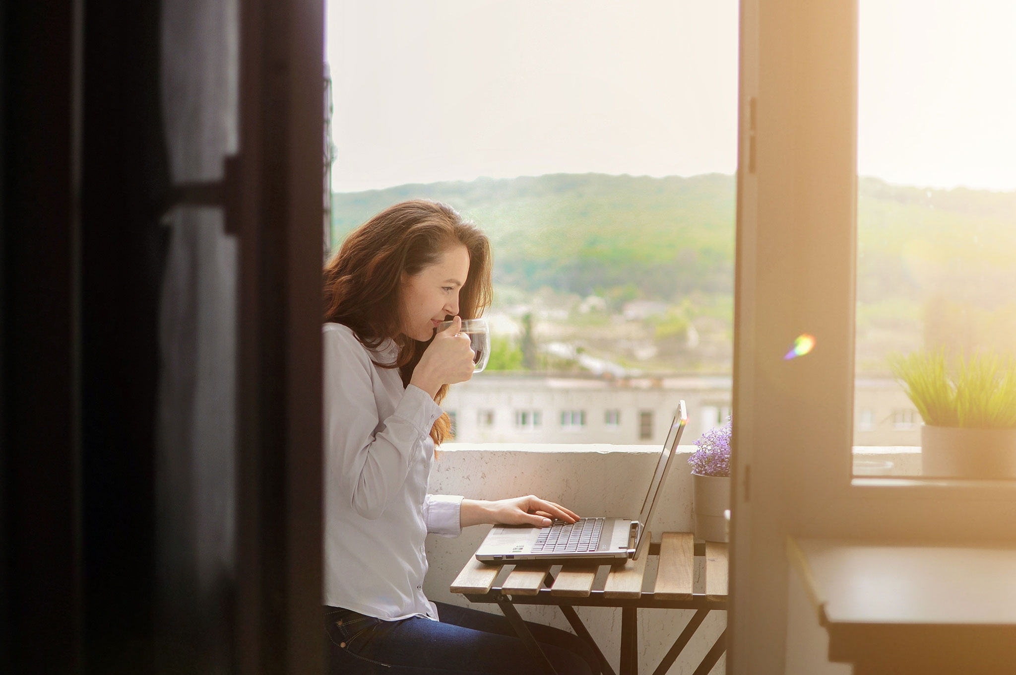 Women working on a laptop with coffee.