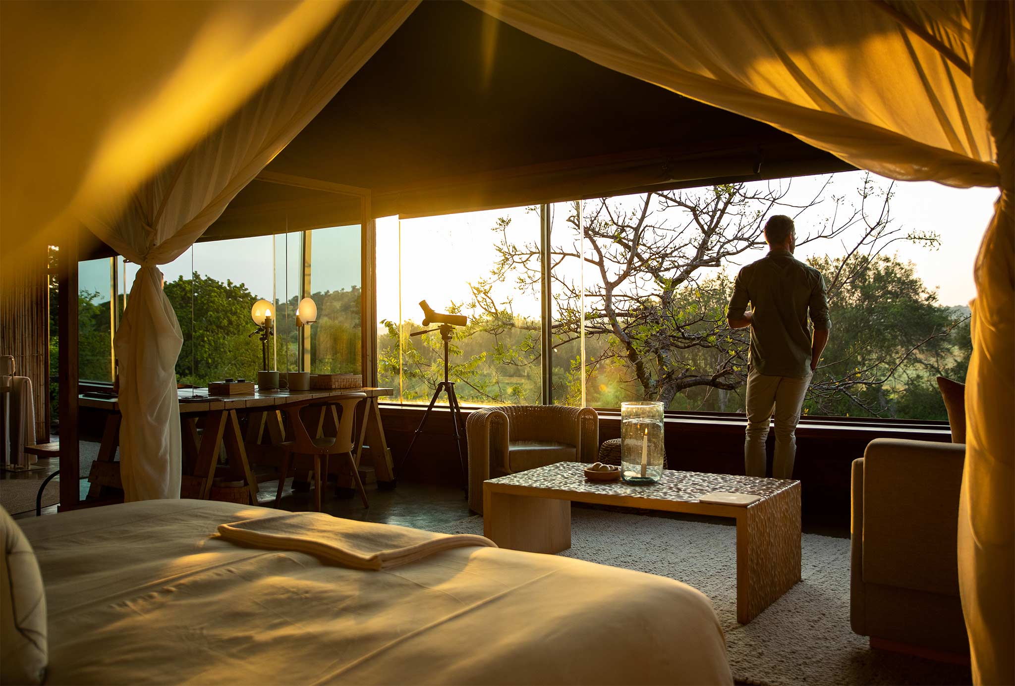 Man looking out at view from a safari lodge in Africa