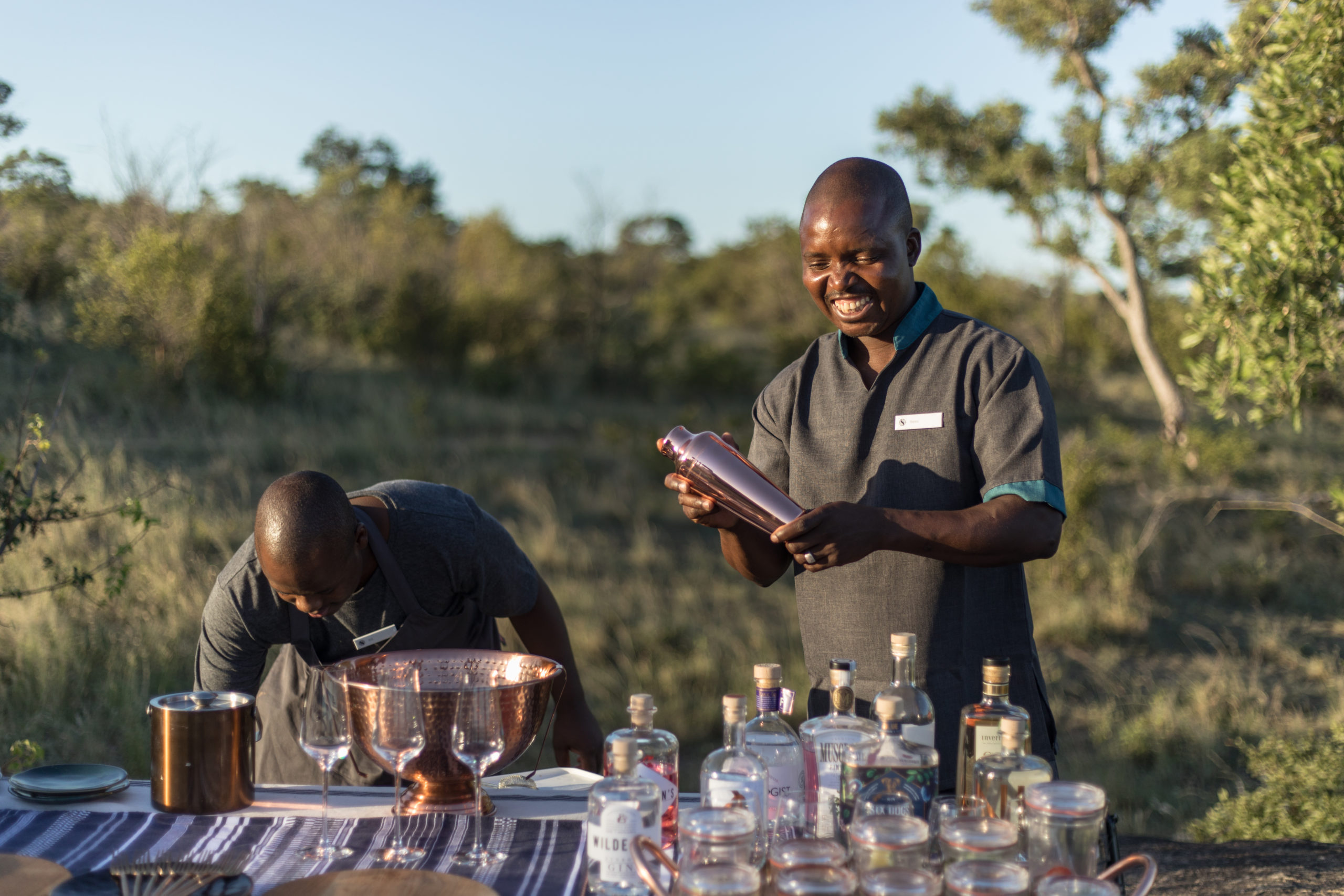 Silvan Butlers pouring drinks on a game drive.