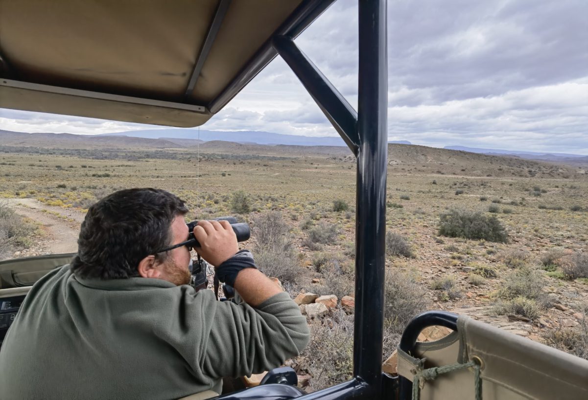 Guide Christopher looking out with binoculars at Snabona Wildlife Reserve