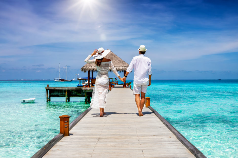 Couple walks to their floating bungalow - best time to visit the Maldives for a romantic holiday