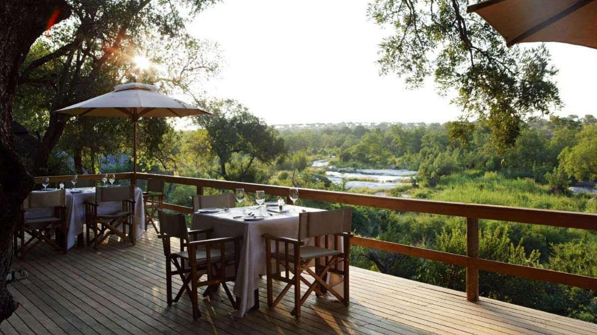 Dining table set for two overlooking the river at Varty Camp