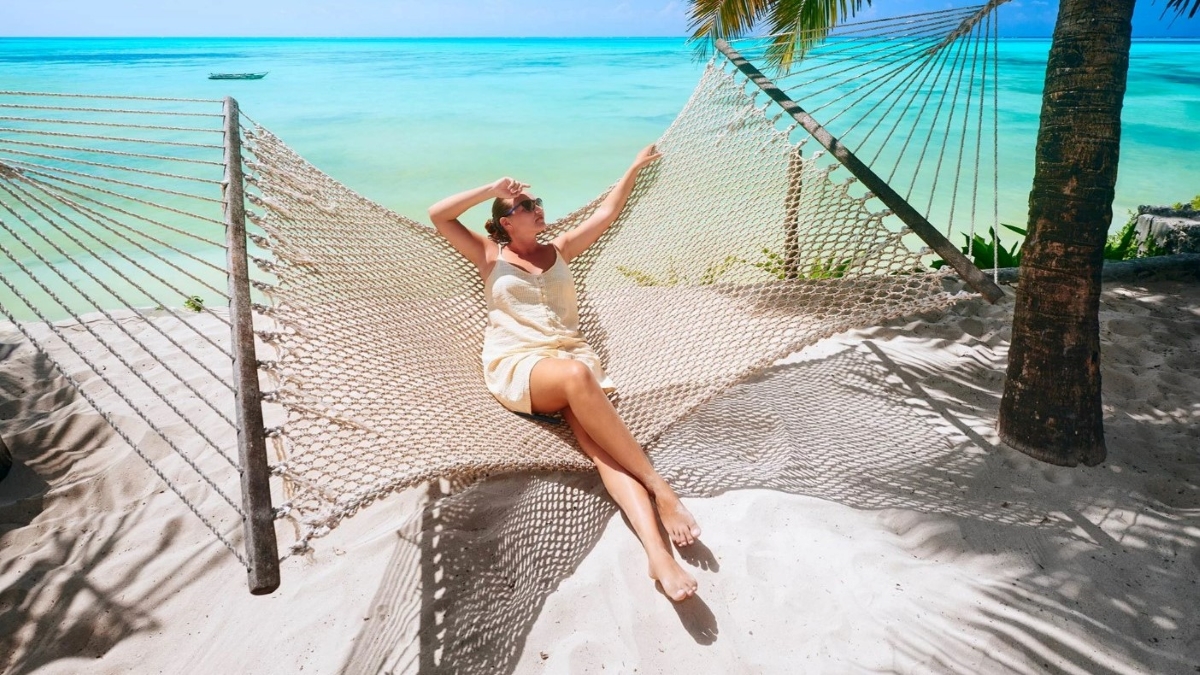 Woman relaxing on a hammock on a pristine beach