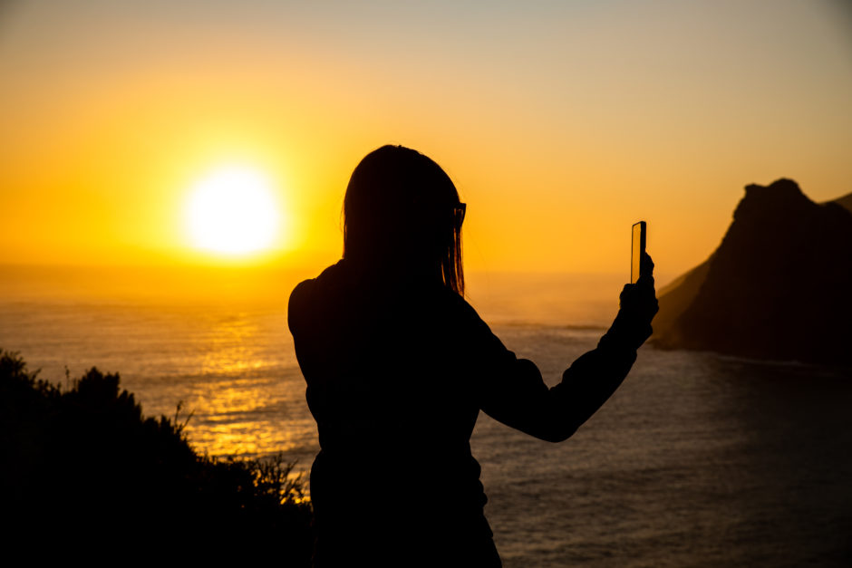 Girl taking a photo at golden Hour on Chapmans Peak Drive