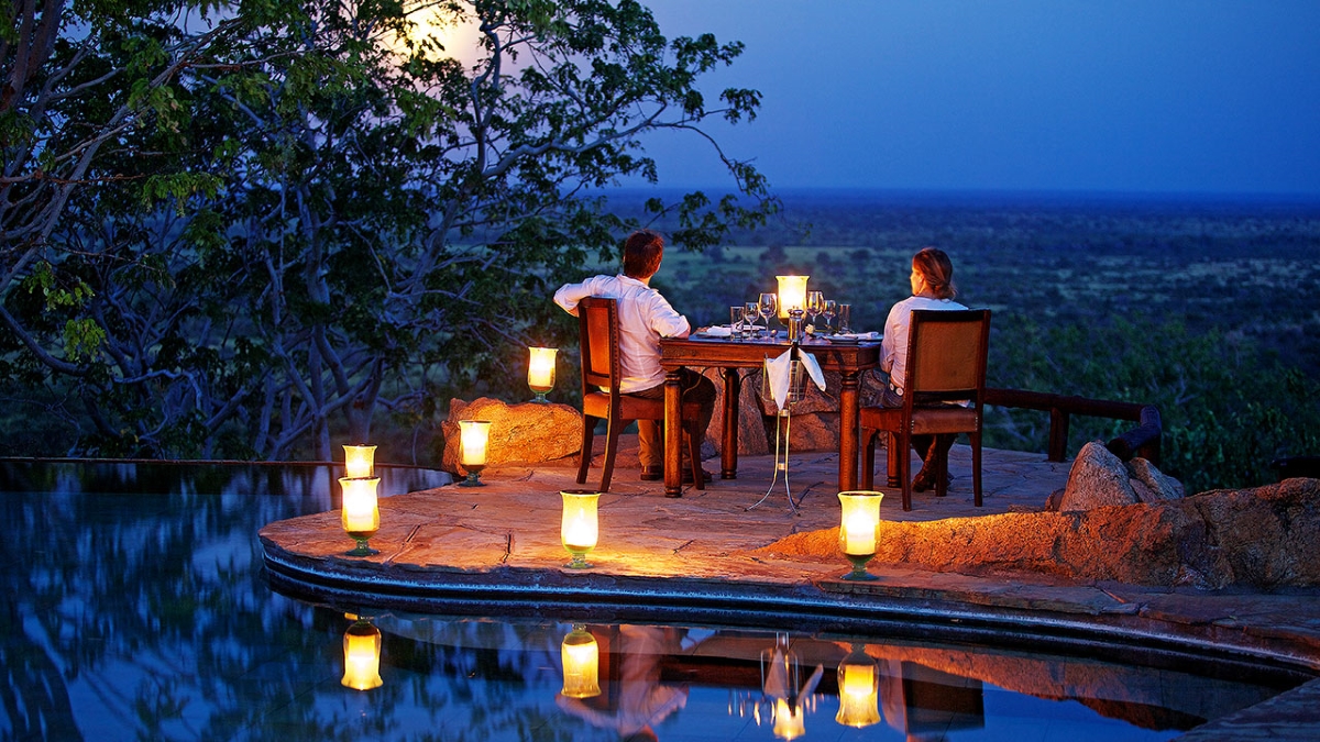 A private evening dinner on the pool deck illuminated by soft-glowing lanterns