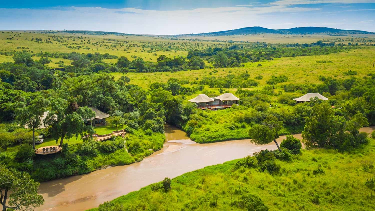 Aerial view of Sala's Camp shown along a swollen river and surrounded by lush green vegetation