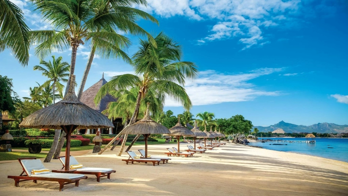 Loungers and thatch umbrellas on a white sandy beach