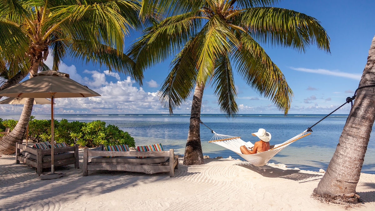 Woman in a hammock on a palm-fringed beach