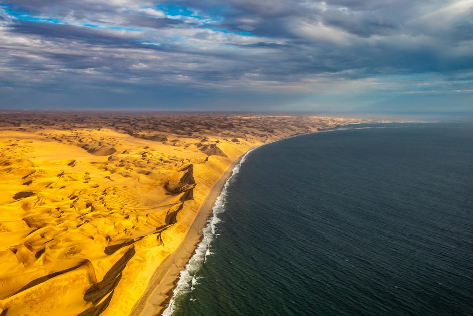 An der Skelettküste treffen rote Sanddünen auf den blauen Ozean