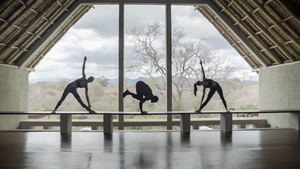 Three people doing yoga on elevated deck