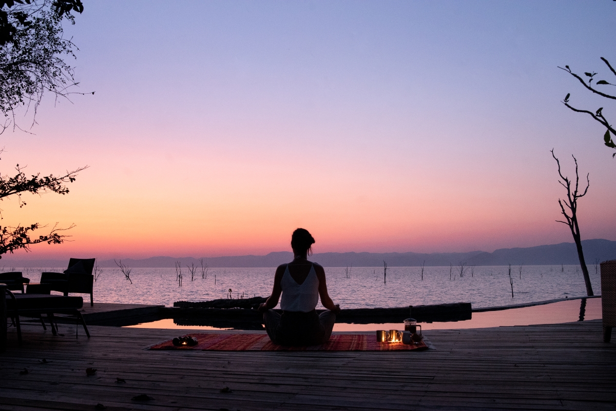 Woman meditating at sunset overlooking Lake Kariba