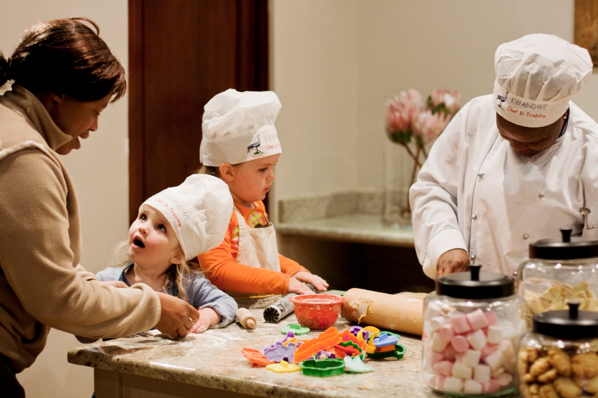 Little children learning how to bake cookies in the lodge kitchen