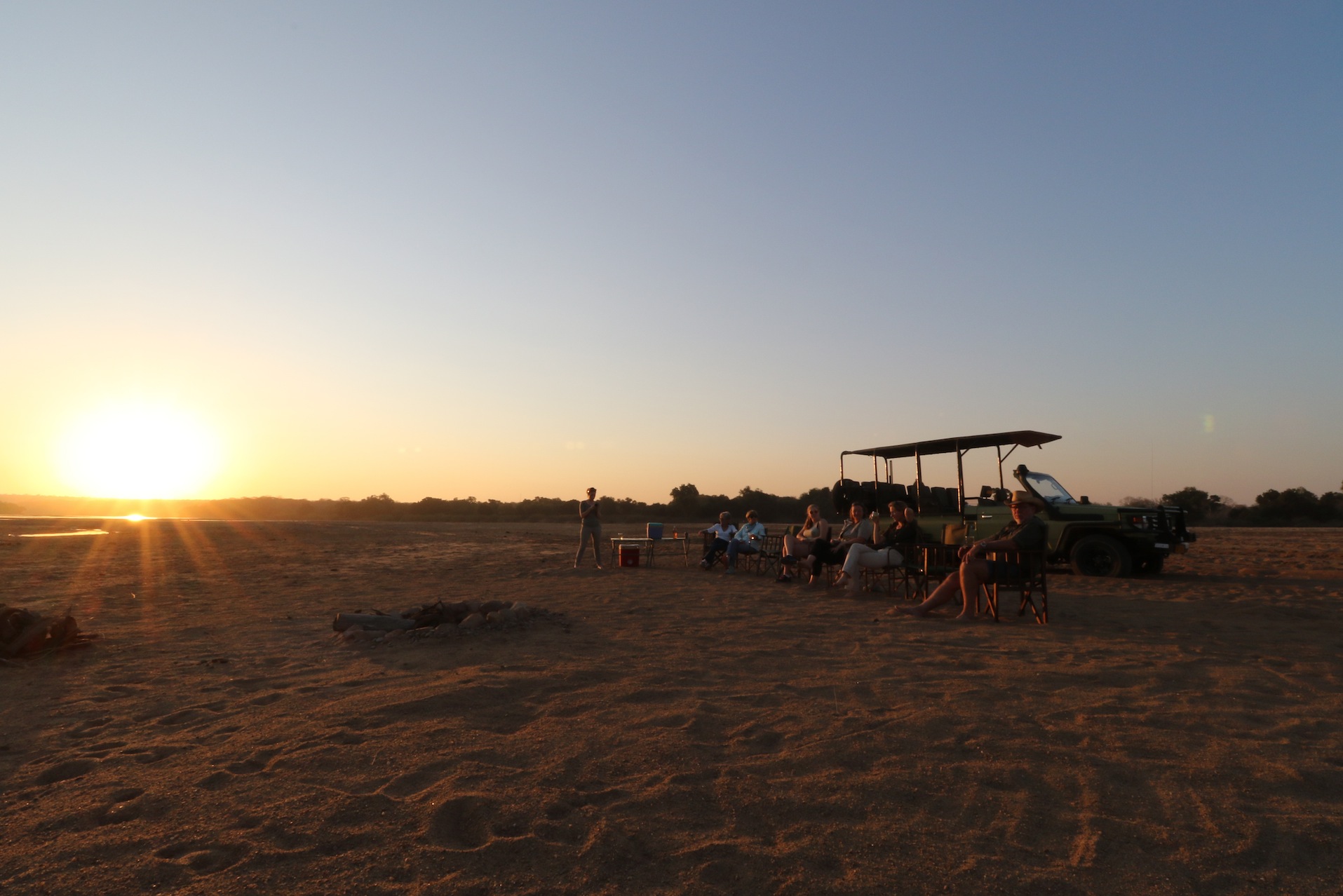 Guests gathering for a sundowner in the wilderness after their game drive