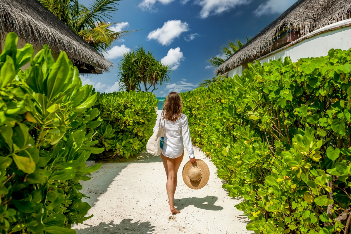 When to Visit Mauritius; Woman with a sunhat walking towards the beach