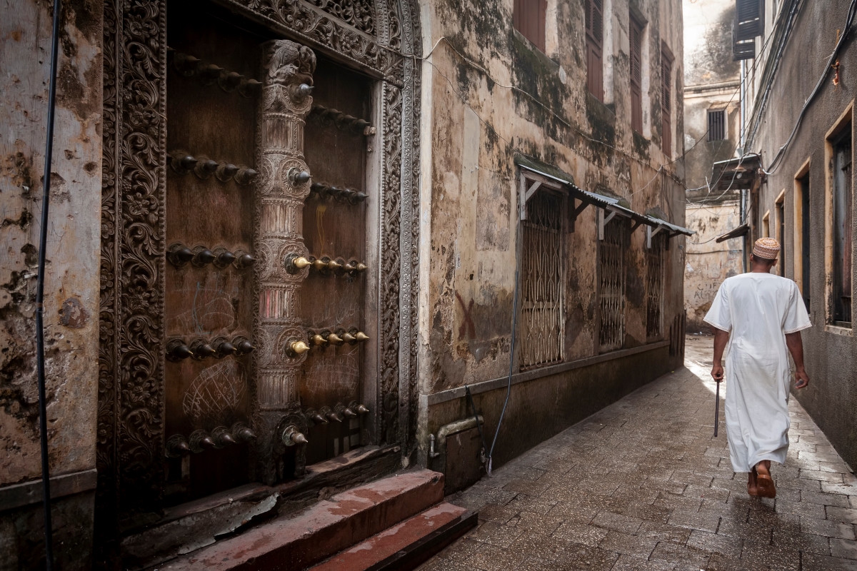 An Islamic man walking through narrow streets of Stone Town