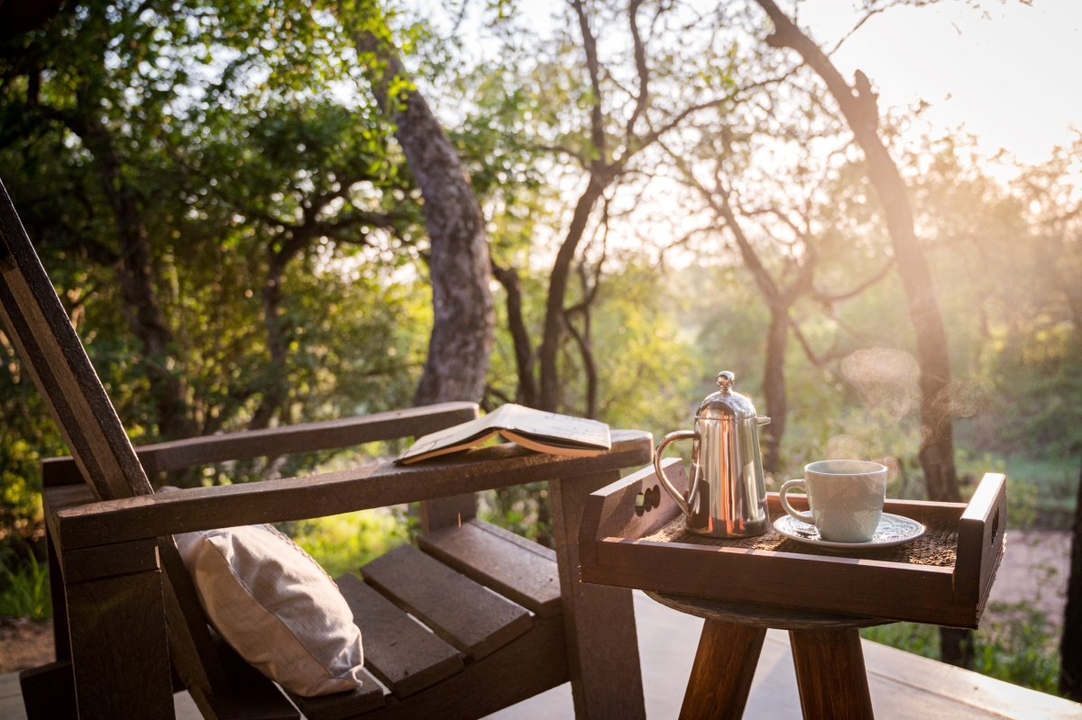 empty chair with side table adorned with tea and coffee, on the private outdoor viewing deck