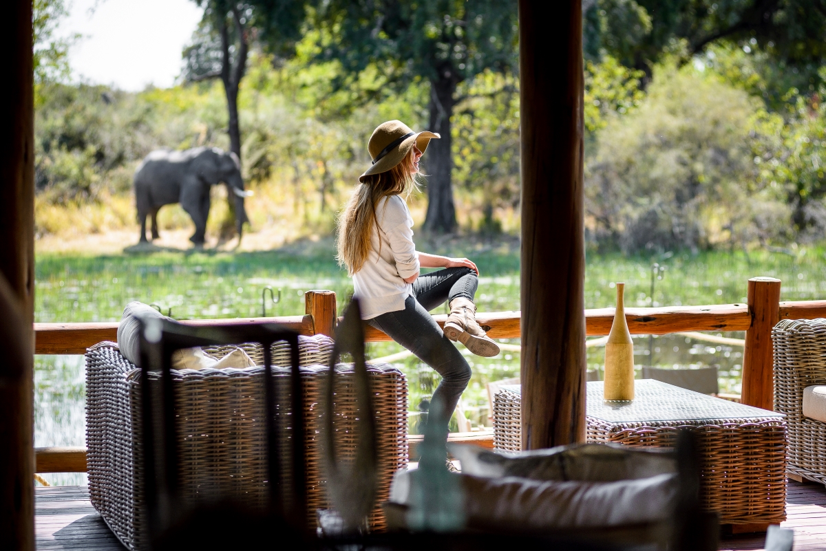 Woman on the viewing deck with an elephant in the distance