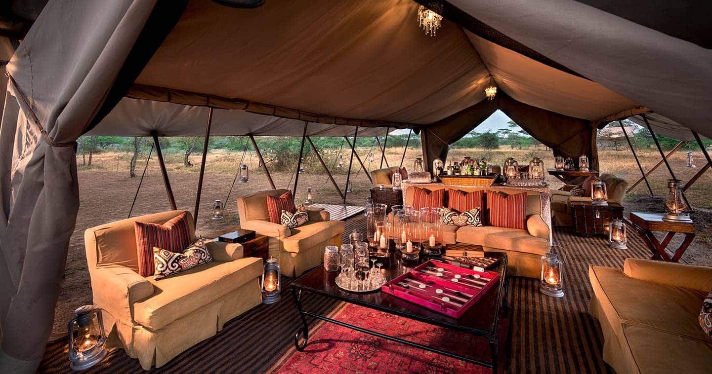 Opulent dining tent adorned with couches and old-world safari charm