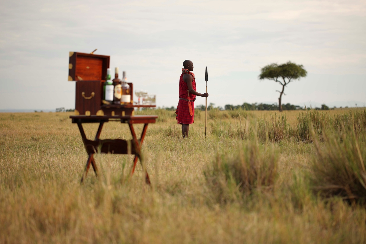 Maasai warrior waiting to welcome guests for a bush sundowner after their game drive