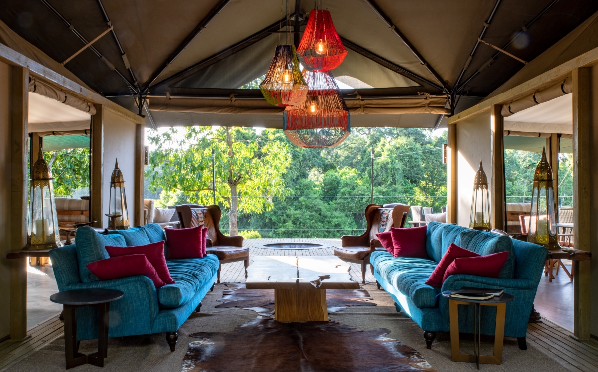 Main area with oversized blue couches and a central, colourfully beaded chandelier, 