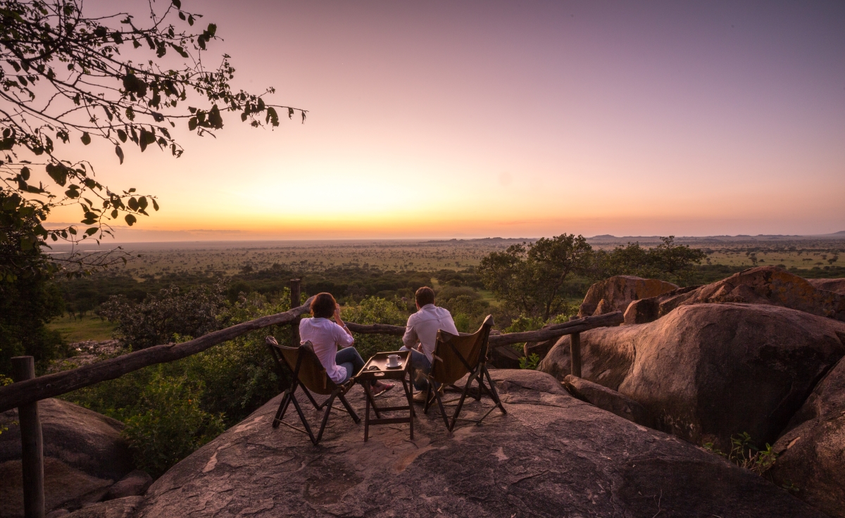 Couple sitting on the kopje observing the sunrise