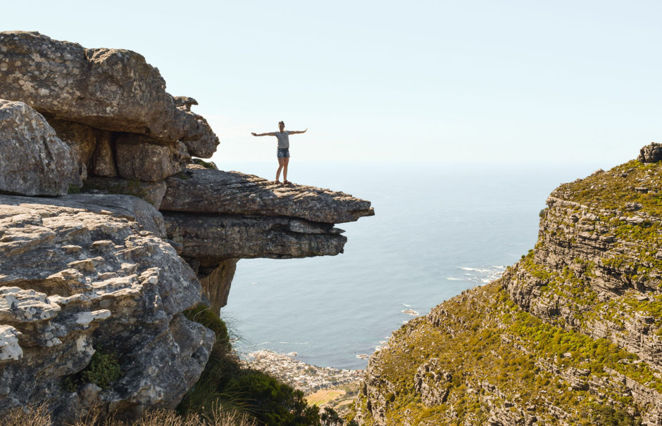 Wanderlust in Kapstadt: Frau steht am Rand des Tafelbergs