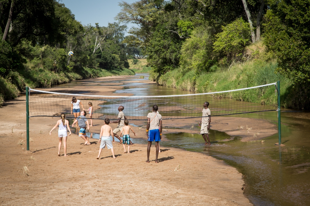 Children and staff playing riverbed volleyball