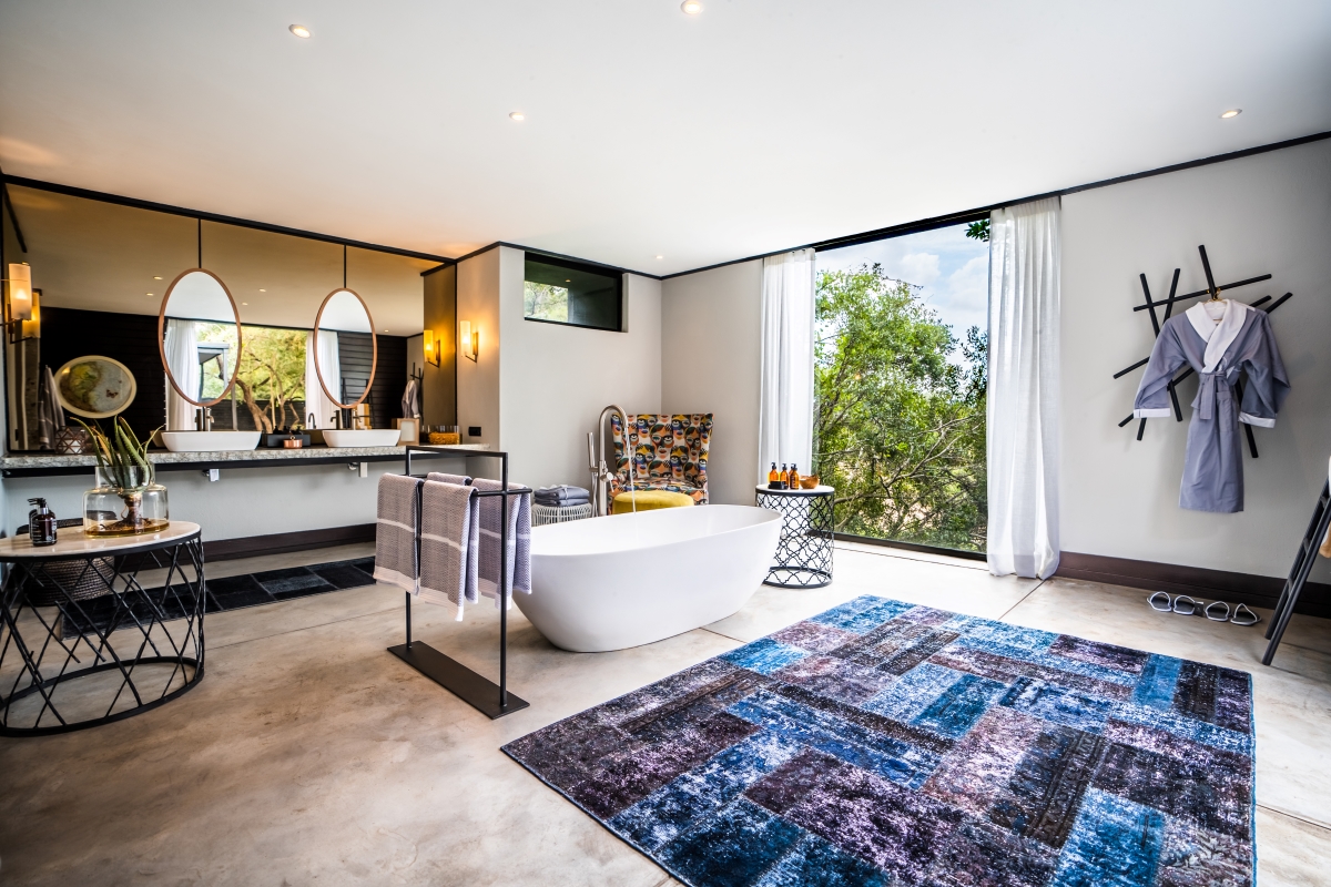 Spacious bathroom with floor-to-ceiling window with wilderness views