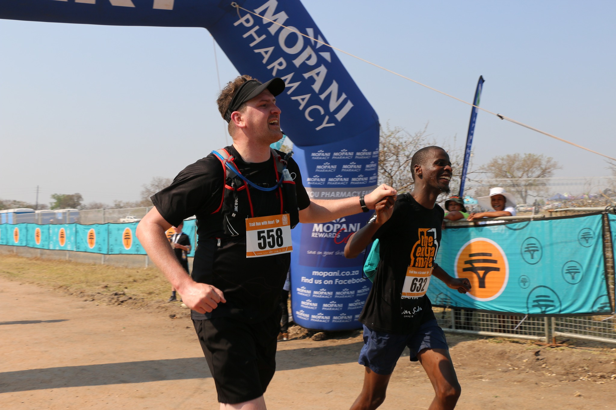 Brad Mitchell and other participant crossing the finish line hand in hand