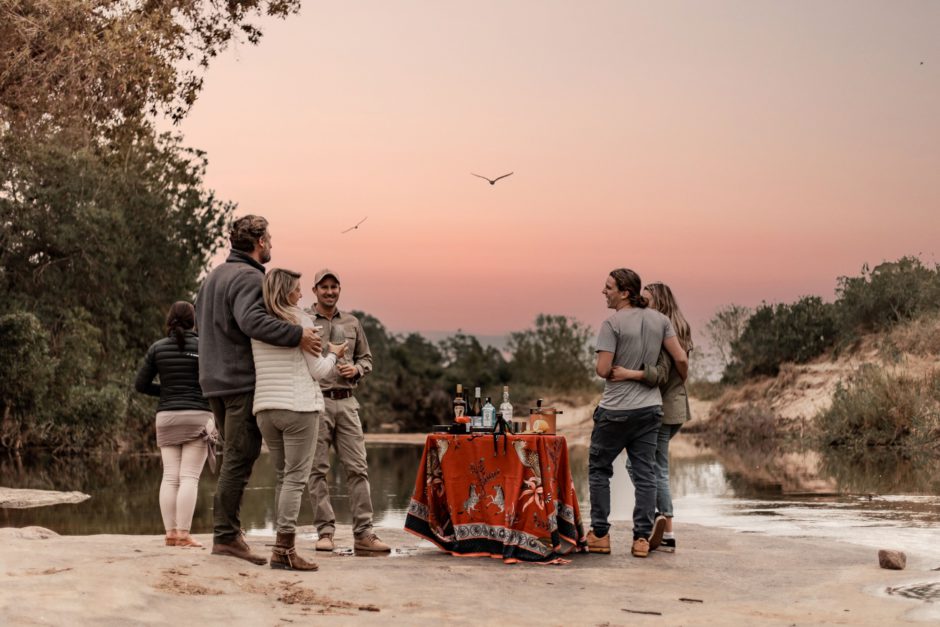 Paare beim Sundowner auf Safari in Südafrika