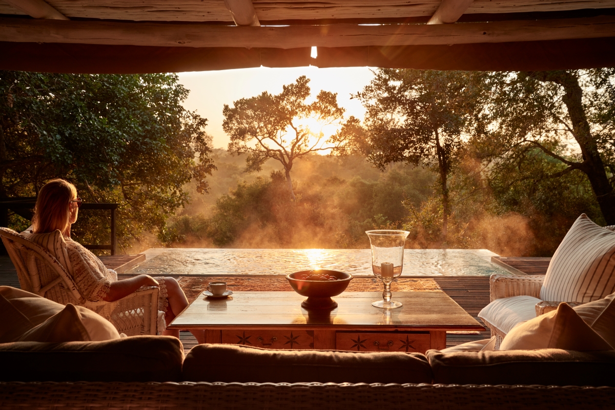 Woman enjoying the sunrise in the wilderness from her private deck