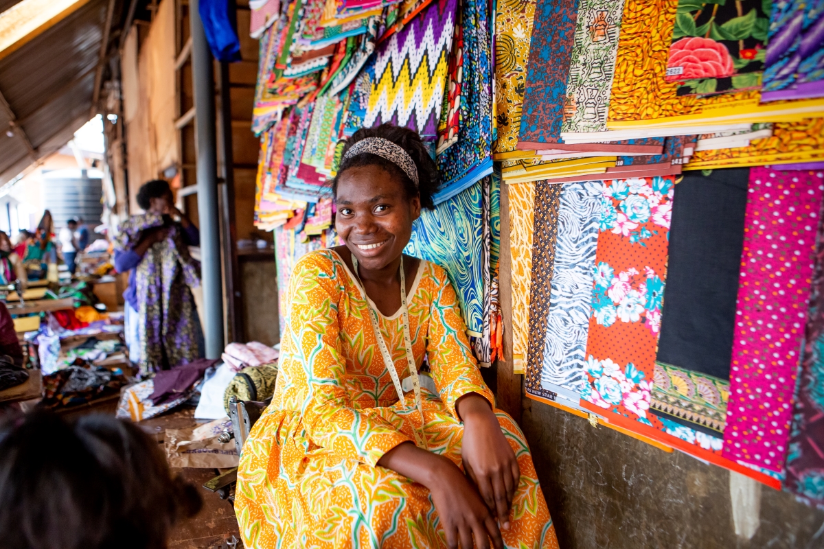 Rwandan woman smiling in front of her textile stall