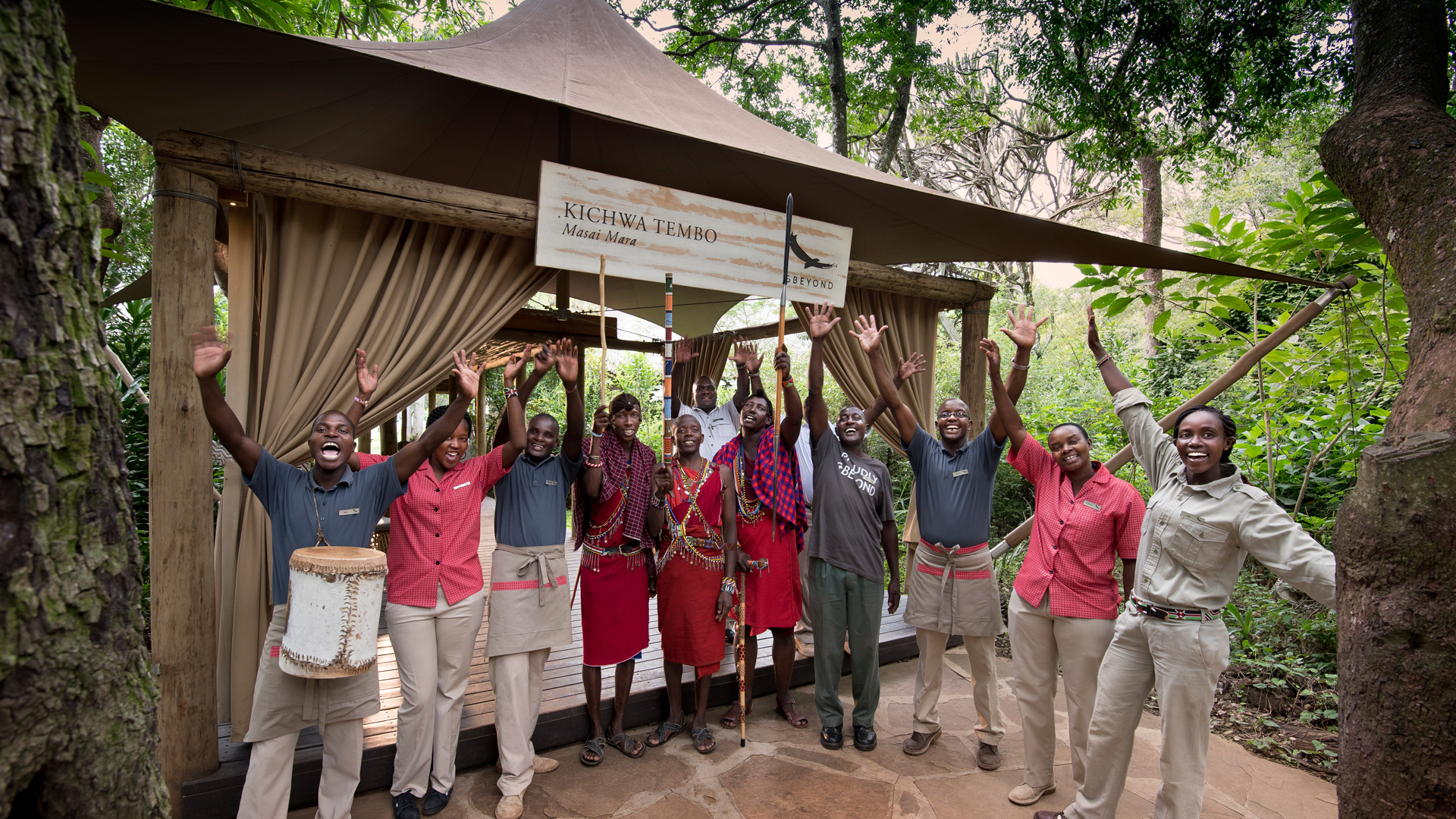 Staff at Kichwa waving at the camp's entrance 